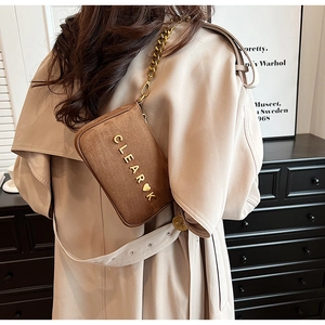 Detail shot of brown suede crossbody bag with gold chain strap and metal logo