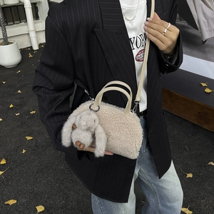 Close-up of plush beige mini crossbody bag with cute rabbit pendant and faux leather straps