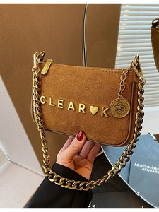 Brown matte suede shoulder bag with chunky gold chain strap and metal logo accent