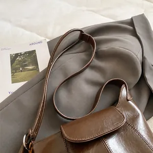 Detailaufnahme von verstellbarem Gurt und Nähten an brauner Vintage-Beuteltasche