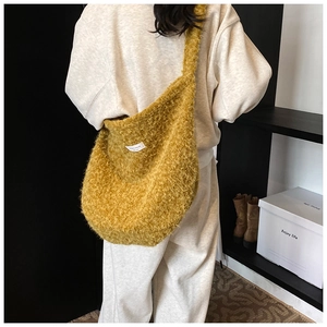 Détail du grand sac bandoulière en peluche jaune moutarde avec texture laine et étiquette