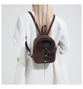 Detail of a brown mini backpack with unique shirt collar design and logo pocket patch