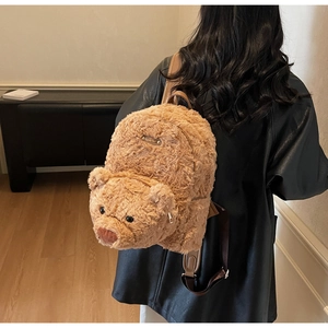 Detailed view of the soft plush bear backpack texture with leather handle and metal logo
