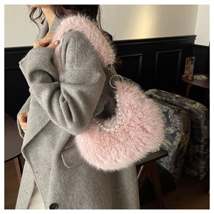 Borsa a mezzaluna in finta pelliccia rosa con manico di perle su cappotto grigio