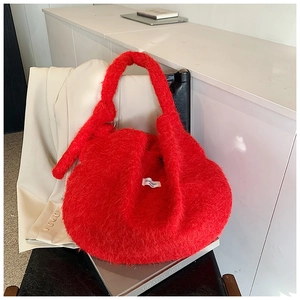 Vue détaillée du sac à main en peluche rouge avec large anse et étiquette tissée décorative