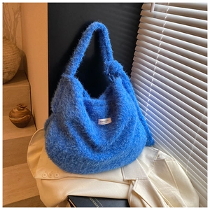 Détail du sac hobo bleu Klein en laine duveteuse avec une finition texturée à poils longs