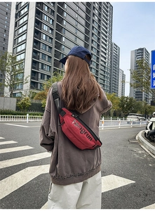 Κόκκινη τσάντα χιαστί με υφή ripstop και ρυθμιζόμενο μαύρο ιμάντα σε εξωτερικό χώρο