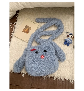 Dettaglio della simpatica borsa shopper blu in peluche con viso cartoon e fiocco 3D