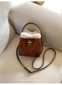 Gros plan du sac en daim marron avec bordure en fausse fourrure blanche et fermoir doré