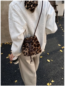 Detalle del bolso de peluche con estampado de leopardo, lazo de cuero y cierre de cordón