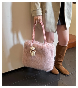 Nahaufnahme der rosa Plüsch-Tasche mit geflochtenen Seilgriffen und weißem Bär-Anhänger
