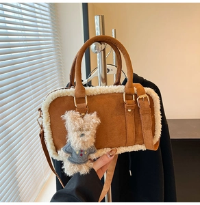 Detalle de bolso de ante marrón con ribete de borreguito y un dije de oso de peluche