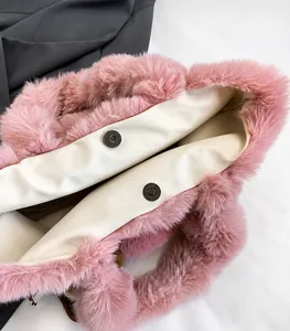 Dettaglio della borsa in peluche rosa che mostra la doppia chiusura magnetica in metallo
