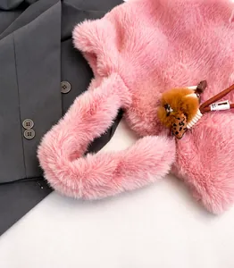 Dettaglio borsa a mano rosa pelosa con ciondolo pompon e fiocco maculato chic