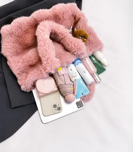 Ampia borsa tote in ecopelliccia rosa che mostra la capacità interna con oggetti vari