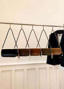 Detail of minimalist underarm bags in five colors with wooden bead charms and retro design