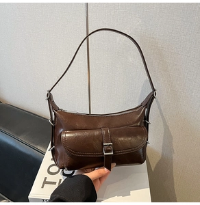 Detail of vintage brown oil-wax leather hobo bag with silver buckle and flip pocket