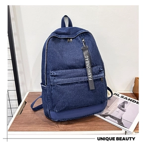 Close-up of durable dark blue denim fabric texture on a large travel backpack
