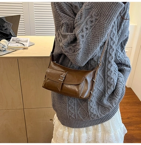 Side view of brown vintage pillow bag in oil wax leather style on model shoulder