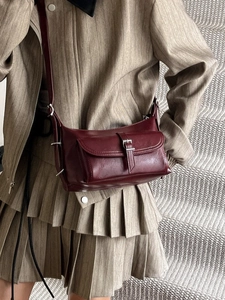 Deep red vintage pillow bag for women with polished leather texture and adjustable strap