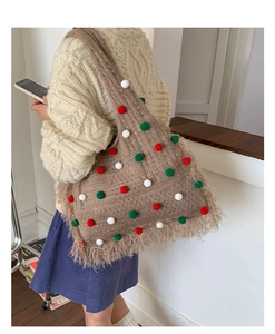 Detail einer braunen Stricktasche mit bunten Bommeln und langen Fransen am Taschenboden