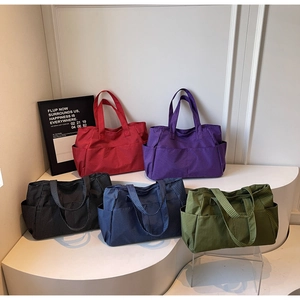 Detalle de bolsos de mano de cuadros en cinco colores con bolsillos laterales