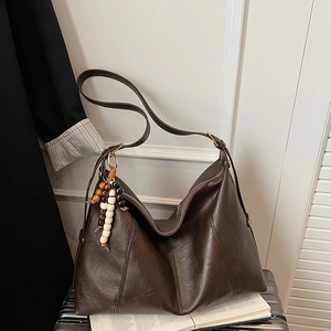 Detail view of large brown vintage PU leather hobo bag with colorful beaded charm