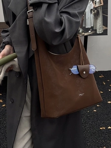 Sac fourre-tout hobo vintage en cuir marron avec logo de marque, vue de profil porté