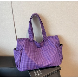 Primer plano del bolso tote de cuadros morados con bolsillos laterales y tela de nailon