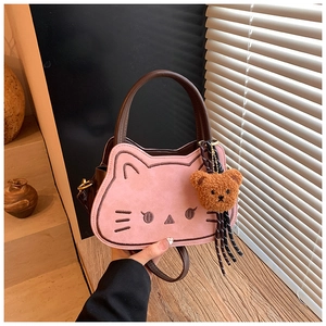 Dettaglio della borsa a gatto rosa e marrone con ricami e ciondolo a forma di orsetto