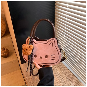 Dettaglio ravvicinato della borsa a gatto rosa con manici in pelle marrone e orsetto