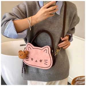 Dettaglio della graziosa borsa a forma di gatto rosa e marrone con ciondolo a orsetto