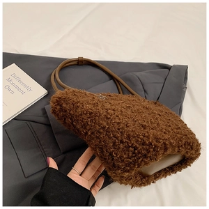 Detailed close-up of brown teddy faux fur texture and leather handle on a stylish bucket bag