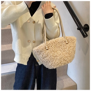 Detail of beige faux fur tote bag with thin leather straps and round bead accents
