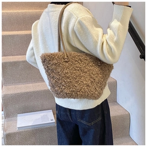 Detail view of brown plush tote bag with soft faux fur texture and slim shoulder straps