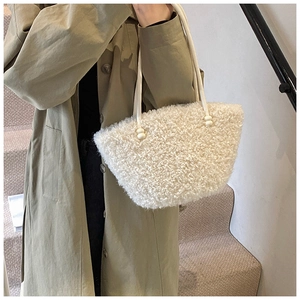 Detail of plush lambskin shoulder bag with textured faux fur and soft rope strap
