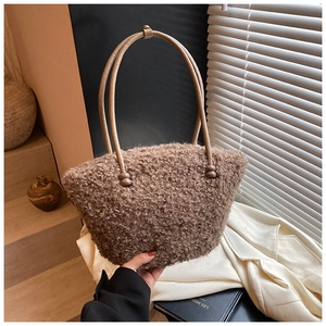 Detailed close-up of brown plush tote bag with slim cream leather handles and bead detail