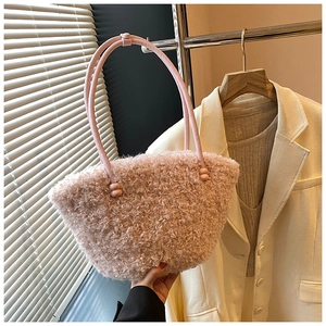 Detail of pink plush bucket bag texture with slim leather handles in a soft setting
