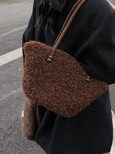 Brown plush shoulder bag with beaded strap shown on model in a stylish autumn outfit