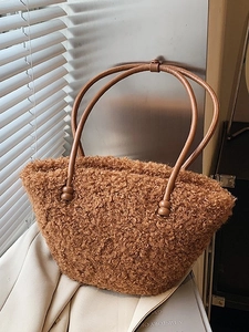 Chic brown plush fuzzy tote bag with leather handles in warm natural lighting