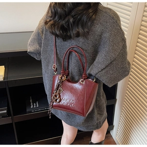 Détail du sac cabas bordeaux mat en cuir texturé avec lettres embossées MKXQ COEOR