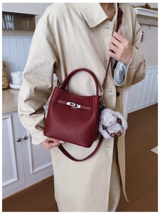 Détail du sac seau bordeaux en cuir avec boucle en métal argenté et breloque lapin en peluche