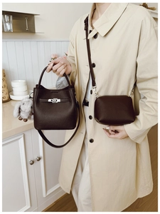 Détail du sac seau en cuir marron foncé avec fermoir argenté et pendentif lapin en peluche
