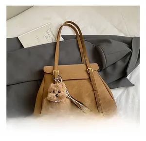 Détail d'un sac cabas en cuir PU marron avec boucle dorée et breloque chien peluche