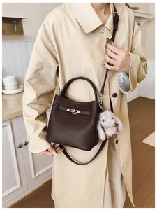 Détail du sac seau en cuir café avec fermoir argenté et breloque lapin en peluche