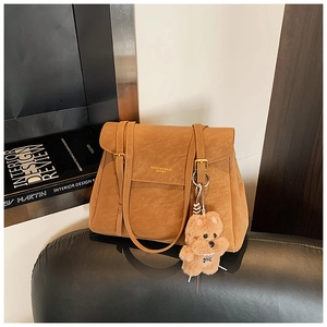 Détail du sac cabas rétro marron avec texture suédée et breloque chien en peluche
