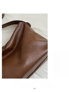 Primer plano de bolso tote marrón vintage con textura de cuero y detalles de costura