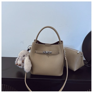 Détail du sac seau kaki avec texture en cuir grainé et breloque lapin en peluche doux