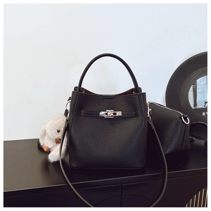 Détail du sac seau en cuir grainé noir avec fermoir argenté et breloque lapin en peluche