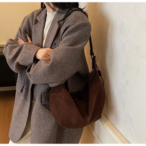 Macro view of minimalist dark coffee suede hobo bag showing texture and crescent silhouette